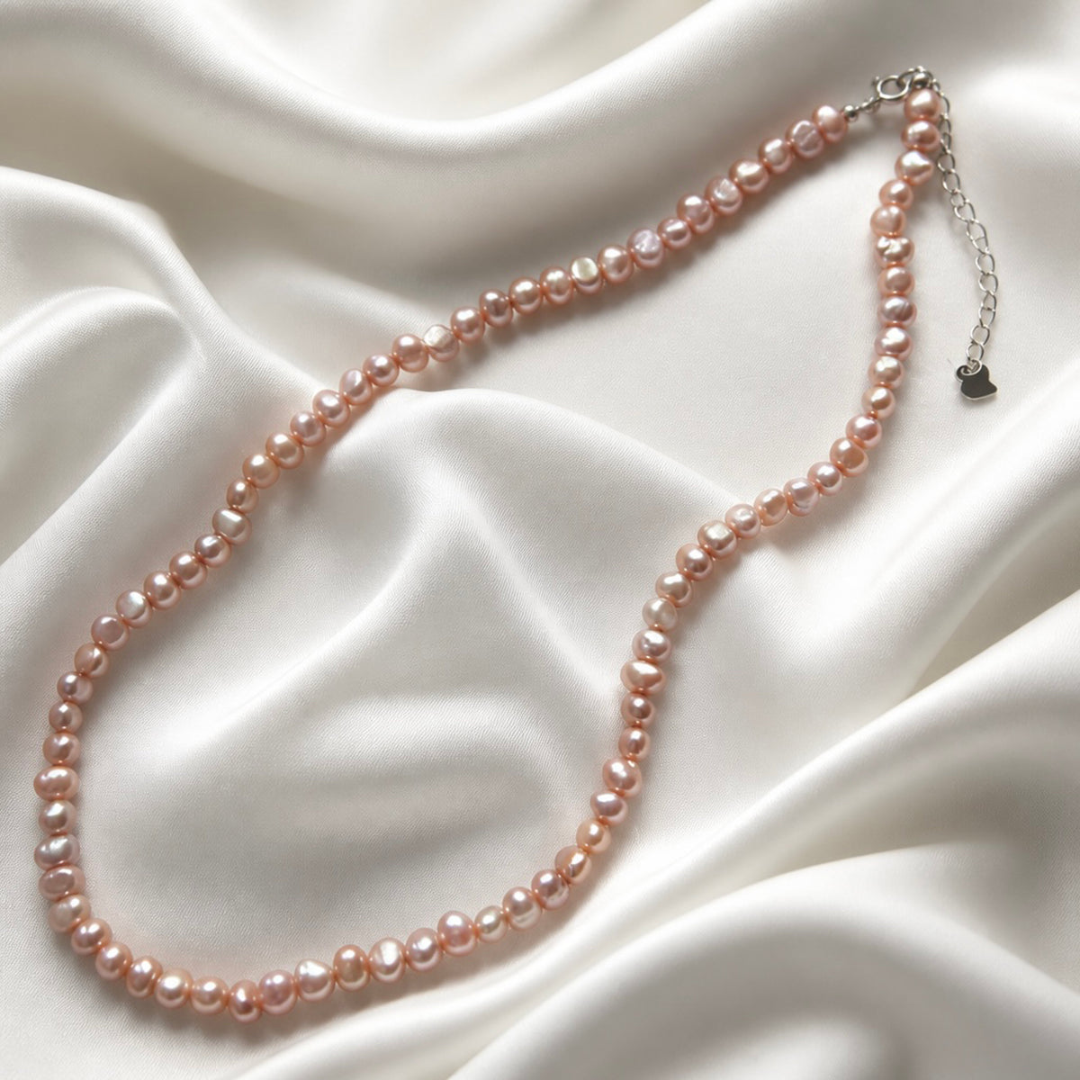 Irregular freshwater pearl necklace — pink/purple satin flatlay